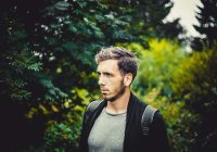 man in gray crew neck shirt and black backpack