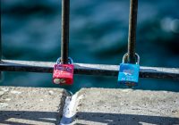 blue and red padlock on grey metal fence